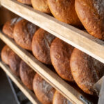 Roberts Bakery Suggests Closure, Endangering 38 Jobs 20-24 years, artisan, baker, bakery, bakery closure, Bread, business news, caucasian, color image, employment, England, Europe, European, fresh, head and shoulders, healthy eating, holding, horizontal, indoors, job loss, large group of objects, loaf, local economy, London, Merchandise, one person, one young woman only, people, photography, quality, Reaching, rear view, retail, Roberts Bakery, shelf, small business, Stocking, United kingdom, Woman, working, young adult Food and Beverage Business